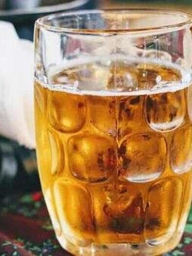A glass of light beer is on a table. The table is covered with a floral patterned tablecloth. | © Mautstüberl Gröbming