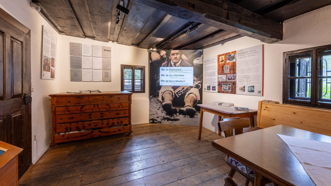 Ein historischer Raum mit Holzböden und Wänden. Auf der linken Seite sind informative Tafeln und eine große Bildprojektion sichtbar. | © Harald Steiner