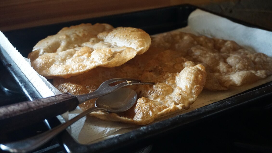 Ein Blech mit frisch gebackenem Teiggebäck liegt auf einem Küchentuch. Darauf befinden sich einige Löffel zum Servieren. | © Naturpark Sölktäler