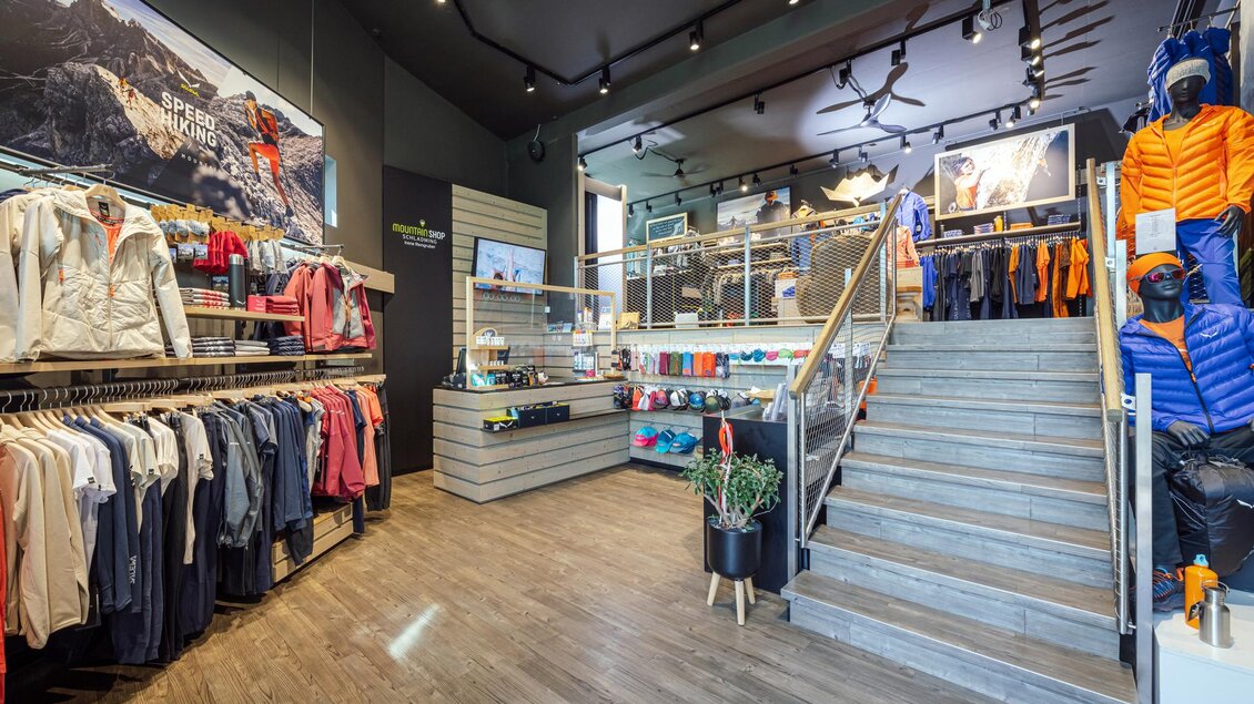 Ein moderner Geschäftsladen für Outdoor-Bekleidung mit einer Vielzahl von Sportkleidung und Zubehör. Die ansprechende Gestaltung und Beleuchtung schaffen eine einladende Atmosphäre. | © Mountain Shop Schladming