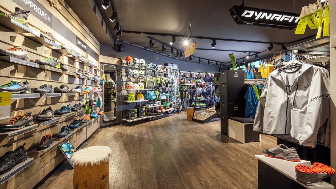 Ein Sportgeschäft mit einer Vielzahl von Schuhen und Outdoor-Ausrüstung. Die Wände sind mit Regalen gefüllt, und die Beleuchtung sorgt für eine einladende Atmosphäre. | © Mountain Shop Schladming