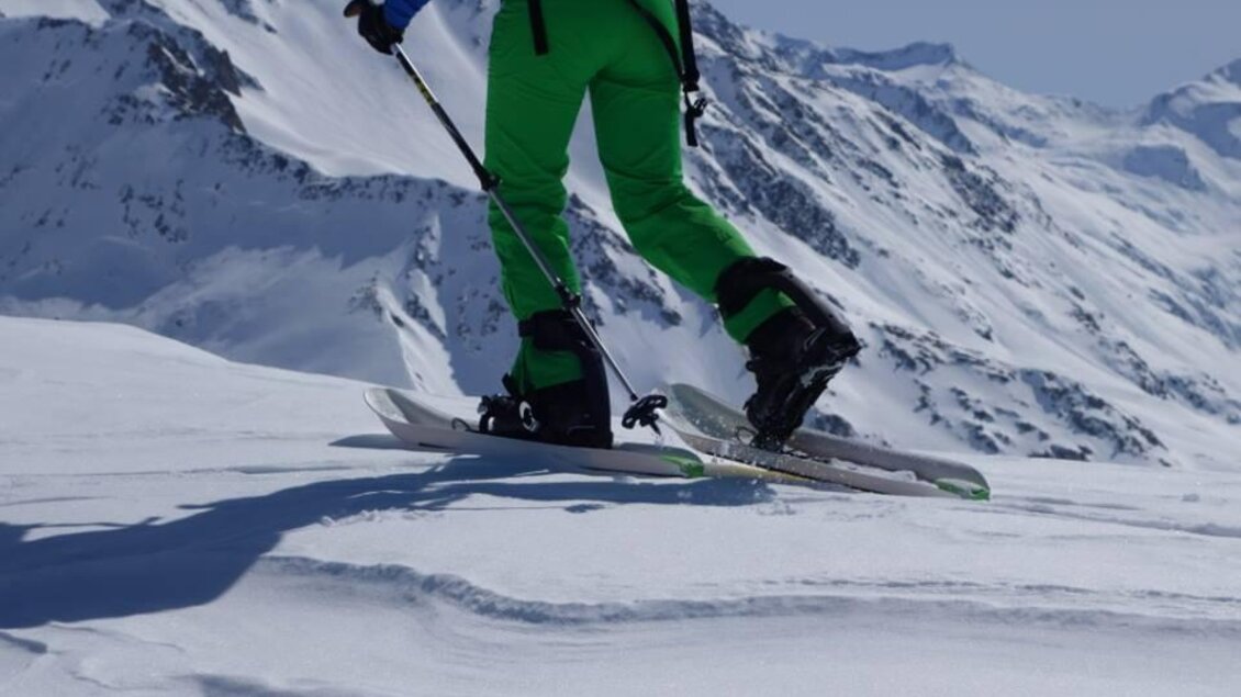 Ein Skifahrer fährt auf einer schneebedeckten Piste. Im Hintergrund sind beeindruckende Berggipfel zu sehen. | © Thomas Humer