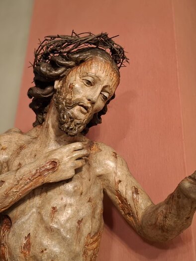 Eine Skulptur von Jesus Christus mit Dornenkrone, die Verletzungen am Körper zeigt. Die Darstellung vermittelt eine tiefgehende emotionale Botschaft. | © Beate Koller