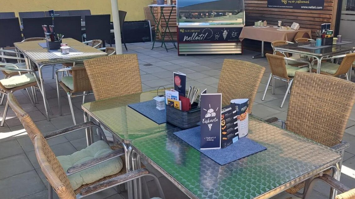 Ein gemütlicher Außenbereich eines Restaurants mit Tischen und Stühlen. Die Tische sind stilvoll gedeckt und im Hintergrund ist eine Theke sichtbar. | © Thomas Bartl