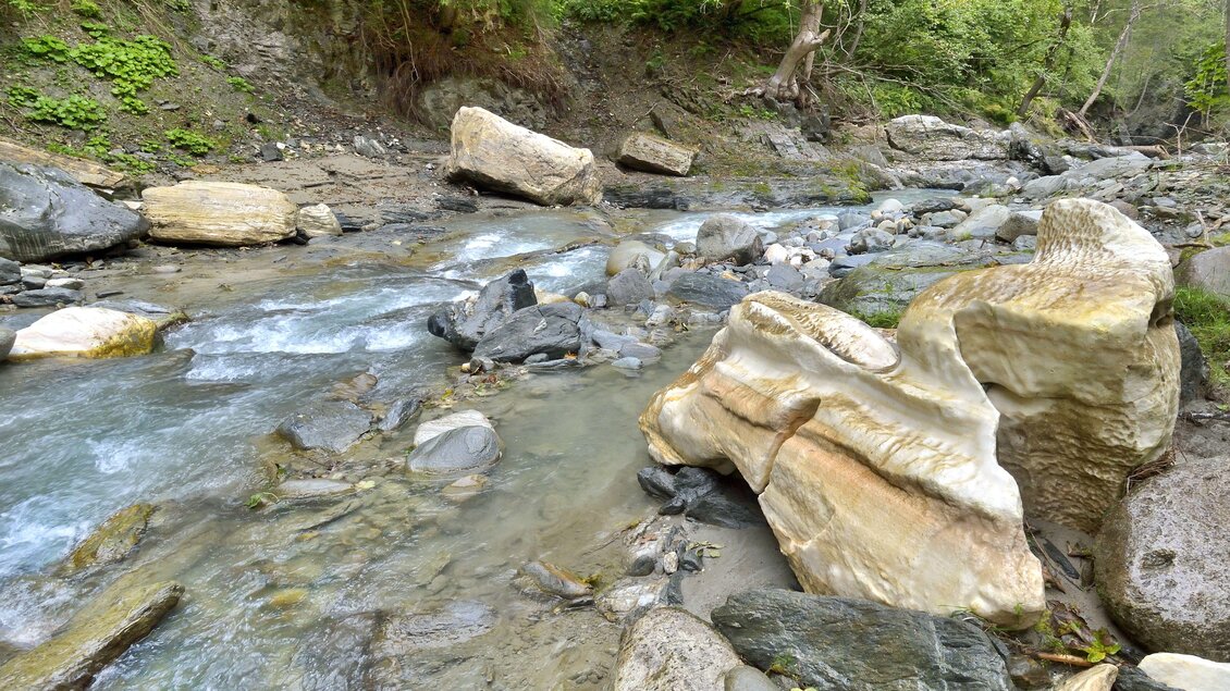 Ein klarer Bach fließt zwischen großen, beeindruckenden Steinen. Die Umgebung ist grün und naturnah. | © Naturpark Sölktäler