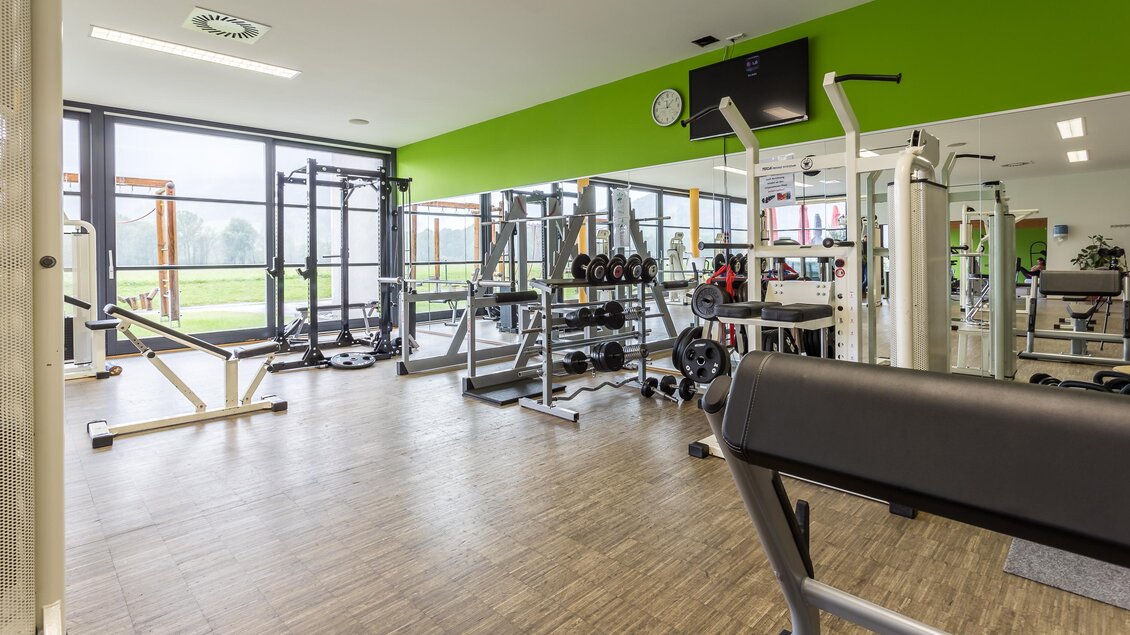 Ein modernes Fitnessstudio mit verschiedenen Trainingsgeräten. Große Fenster lassen viel Tageslicht herein. | © Sportsarea Grimming