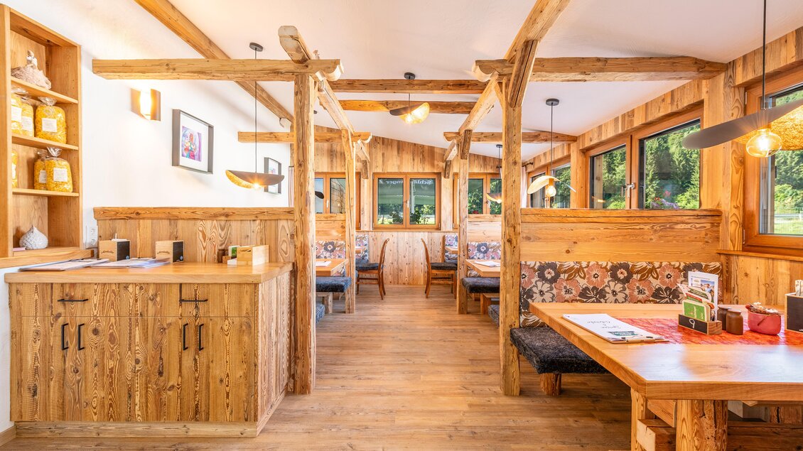 Gemütliches Restaurant mit Holzdekor und großen Fenstern. Die Einrichtung ist warm und einladend, perfekt für eine entspannte Mahlzeit. | © Steirische Hendlstub'n