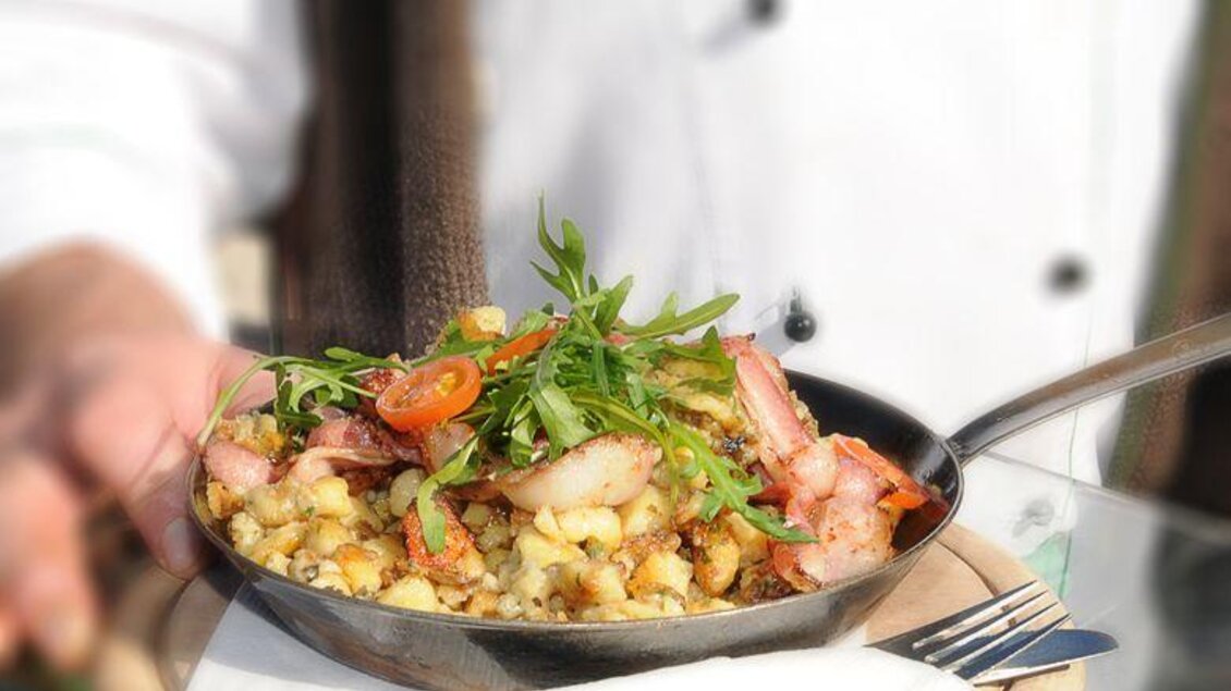 Gericht mit Garnelen, Salat un frischem Kräutern, serviert in einer kleinen Pfanne. | © TOMiziel/Berggasthof Scharfetter