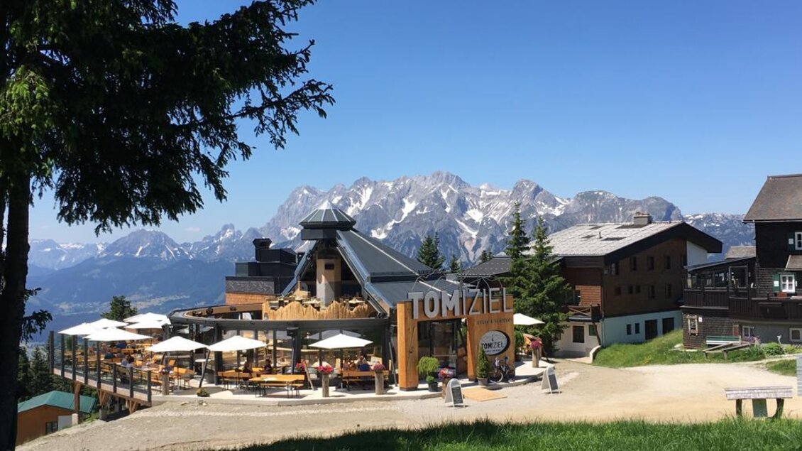 Sommerbild von einer edlen Holzhütte mit einem schönen Bergpanoramablick | © TOMiziel/Berggasthof Scharfetter