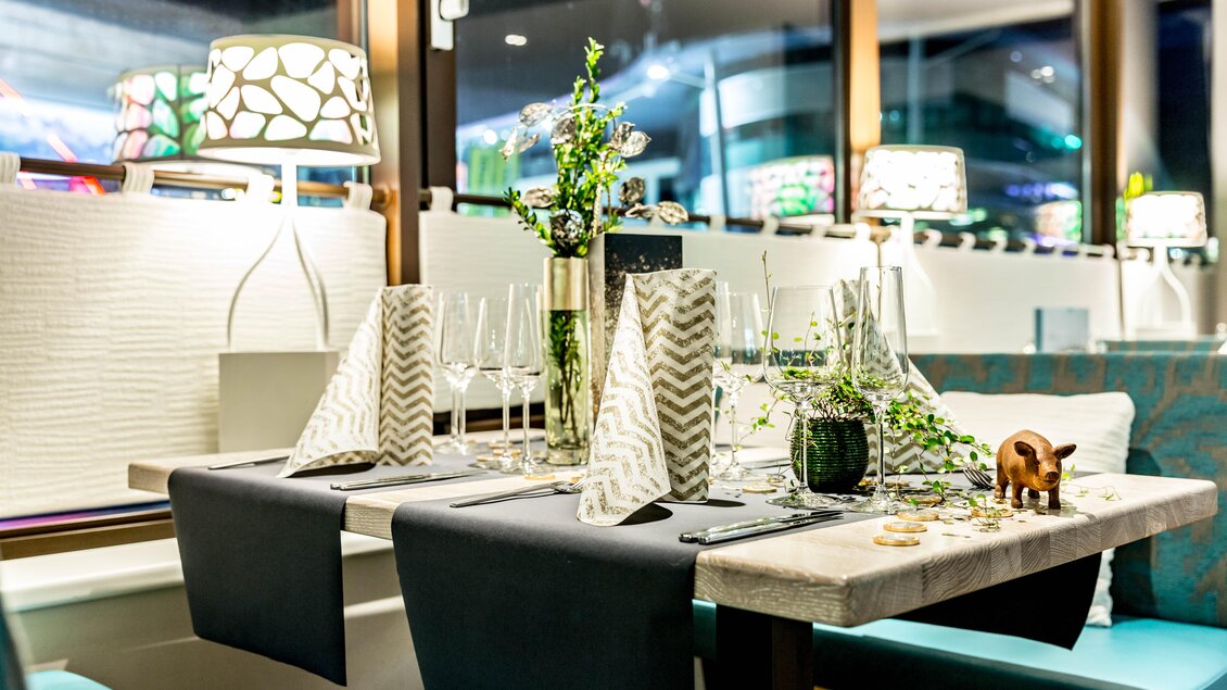 Ein elegant eingedeckter Tisch in einem modernen Restaurant. Die Tischdekoration umfasst Glaswaren und Pflanzen, um eine gemütliche Atmosphäre zu schaffen. | © TUI BLUE