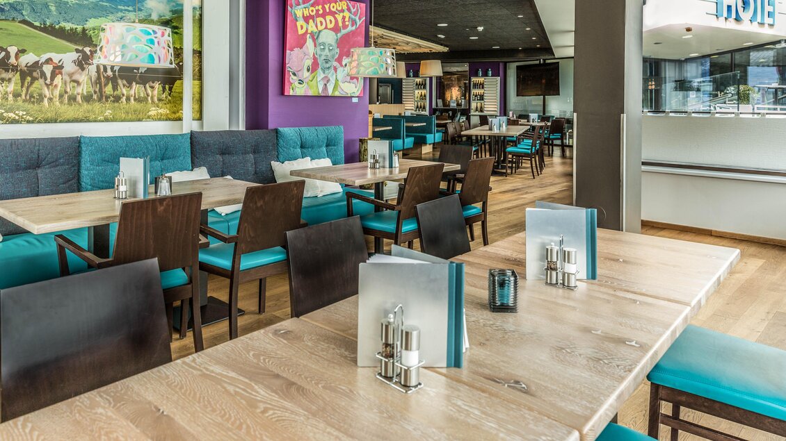 Ein modernes Restaurant mit gemütlichen Tischen und Stühlen. Die Wände sind mit bunten Bildern und einer freundlichen Atmosphäre gestaltet. | © TUI BLUE