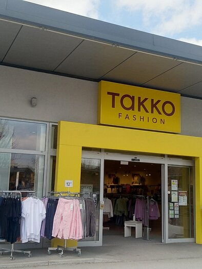 Ein Modegeschäft mit dem Namen "Takko Fashion". Die Eingangstür ist gut sichtbar und es gibt verschiedene Kleidungsstücke in den Auslagen. | © Tourismusverband Schladming