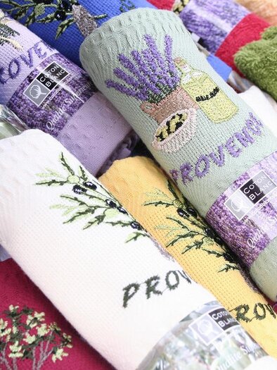 Colorful dish towels with various images and inscriptions that display the word "Provence." The towels are stacked in different colors and showcase floral patterns. | © pixabay