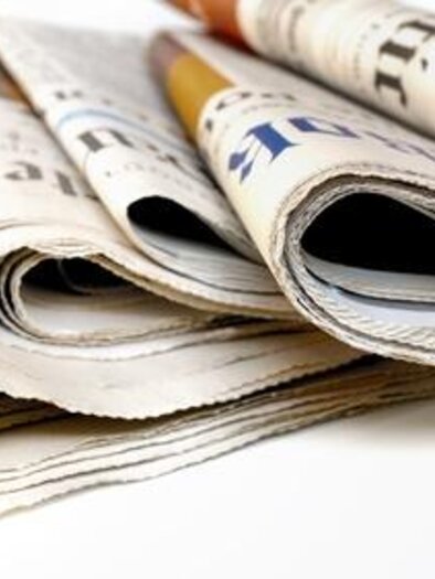 A collection of folded newspapers lies on a table. The newspapers have different titles and are printed in various colors. | © Symbolfoto Fotolia