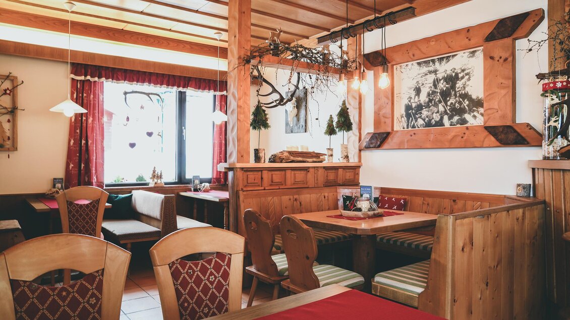 Gemütliches Gasthaus mit Holzdecke, roten Vorhängen und festlich gedeckten Tischen – warme, einladende Atmosphäre. | © Foto Tom