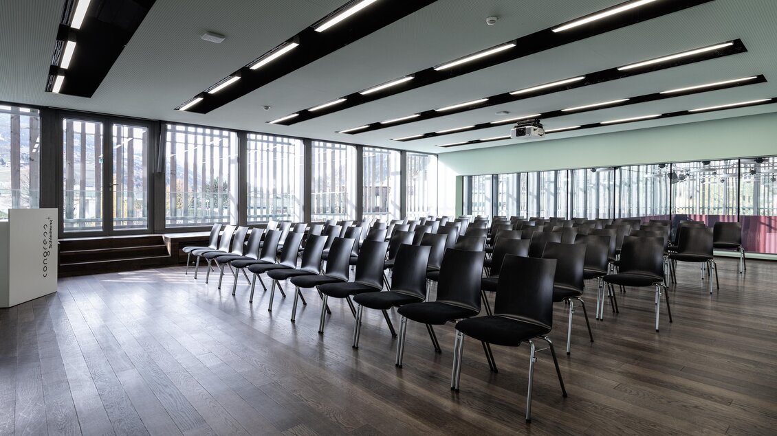 Ein moderner Besprechungsraum mit vielen schwarzen Stühlen. Große Fenster sorgen für viel Tageslicht und eine angenehme Atmosphäre. | © Harald Steiner 