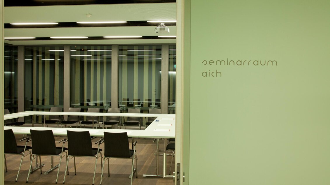 Ein moderner Seminarraum mit einem großen Tisch und Stühlen. Die Wände sind in gedeckten Farben gehalten. | © Harald Steiner