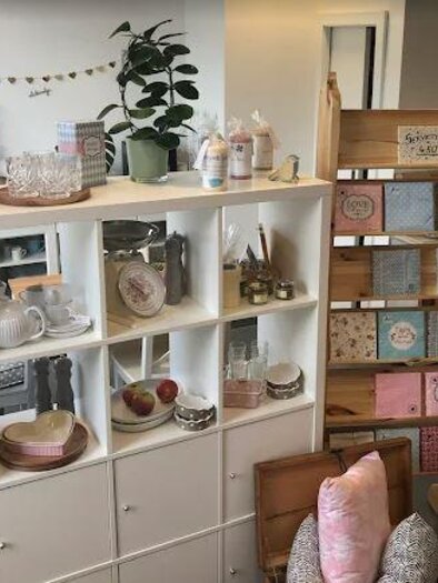 An inviting store with pretty household goods and decorative items. On the left are shelves with dishes and decorative items, and on the right is a stand with cards and notepads. | © entZückend